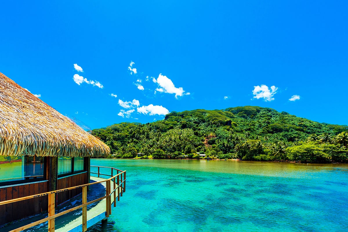 Un bungalow sur les eaux turquoise d'un lagon à Huahine, en Polynésie française.